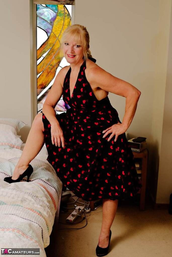 Blonde granny Veronique takes off heels and panties before masturbating