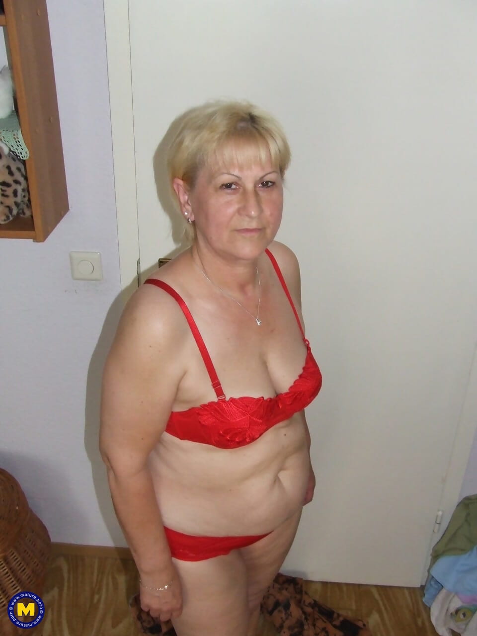 Fatty granny with saggy tits removes red lingerie and poses nude in bedroom