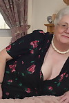 Older granny is still horny and plays with her fatty pussy on the bed