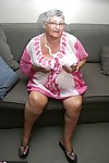Horny Grandma Libby strips and spreads her old shaved pussy on the sofa