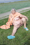 Geeky Grandma Libby flashing her monster mature curves in the filed