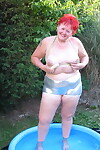 Older redheaded BBW Valgasmic Exposed plays with a dildo in a wading pool