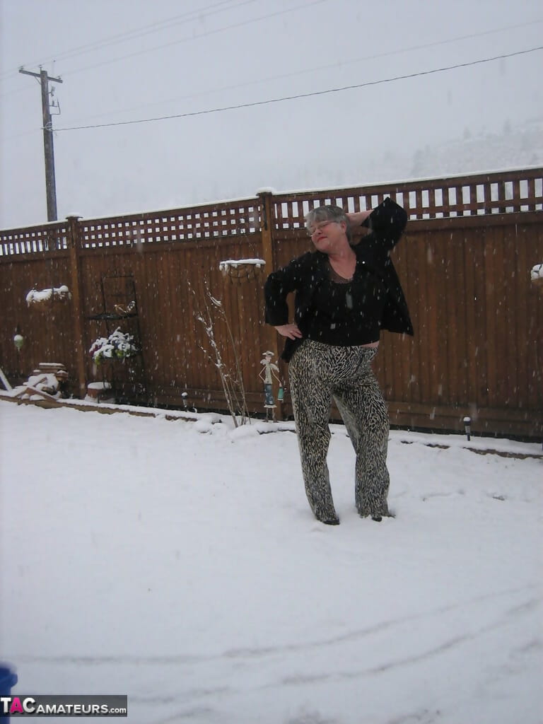 Naughty granny Girdle Goddess strips to her stockings and boots while it snows